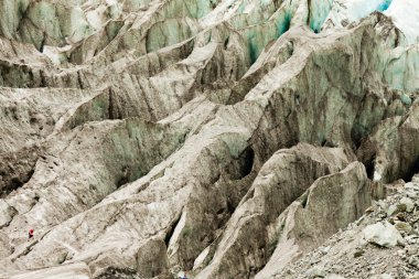 Tiny man walks expansive alpine glacier icefield clipart