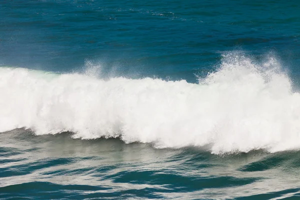 Турбулентна вода розбиває океанську хвилю і розбризкує — стокове фото