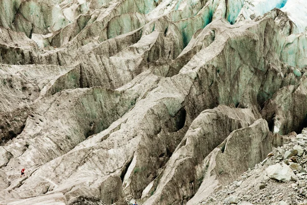 Kleine man loopt expansieve alpine gletsjer ijsveld — Stockfoto