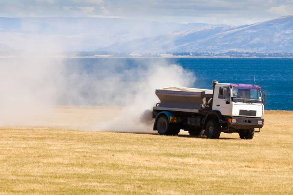 Truck spreading fertilizer on pasture meadow — Stock Photo, Image