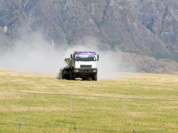トラックの肥料散布牧草地の牧草地に — ストック写真