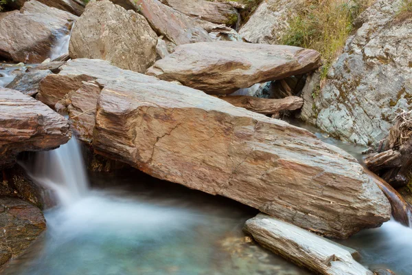 Piccola cascata a cascata su rocce in laghetto blu — Foto Stock