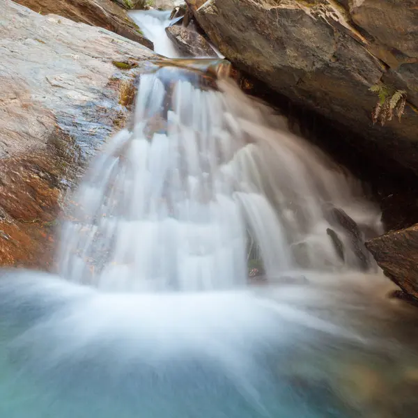 ブルーの池の岩の上の小さな滝 casdcading — ストック写真