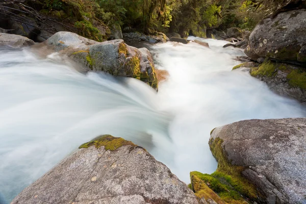 Los rápidos del río se lavan sobre rocas con aspecto sedoso — Foto de Stock