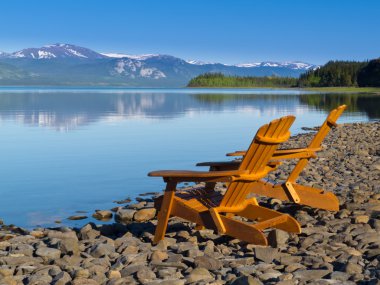 Wooden deckchairs overlooking scenic Lake Laberge clipart