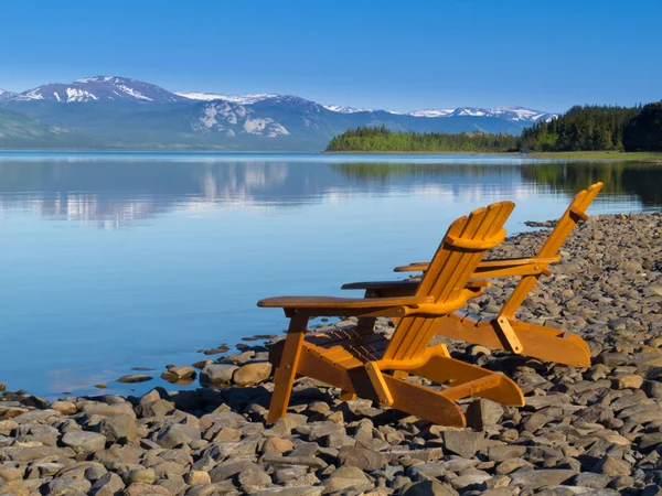 Drewniane leżaki z widokiem na malownicze jezioro laberge — Zdjęcie stockowe