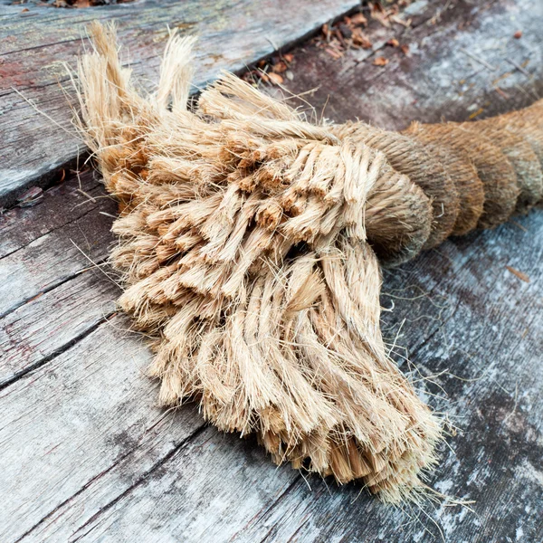 Nött slutet av sisal rope liggande på väderbitna trä — Stockfoto