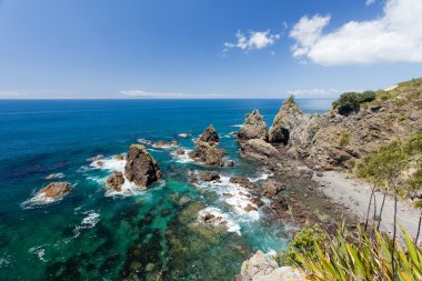 Steep Coastal Cliff Landscape with green clear ocean water clipart