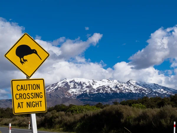 Kiwi Crossing sinal de estrada e vulcão Ruapehu em NZ — Fotografia de Stock