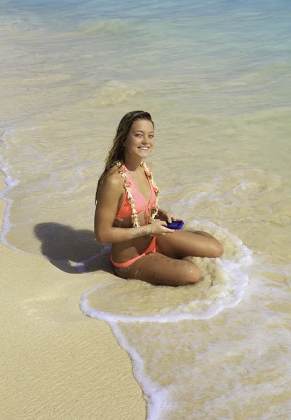 Linda loira em biquíni mensagens de texto na praia — Fotografia de Stock