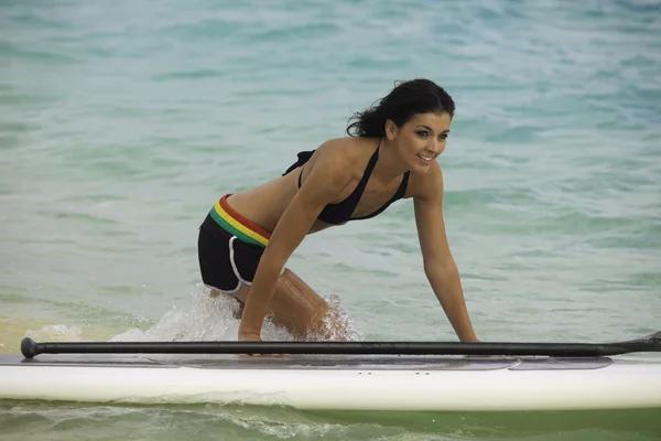 Mujer con su tabla de remo en una playa hawaii — Foto de Stock