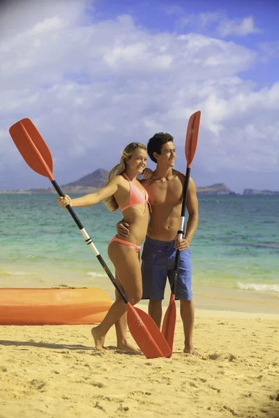 Couple with their kayak at the beach — Stock Photo, Image