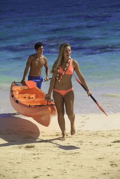 Pareja en la playa con su kayak —  Fotos de Stock