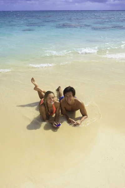 Par på stranden i hawaii med sin mobiltelefon — Stockfoto