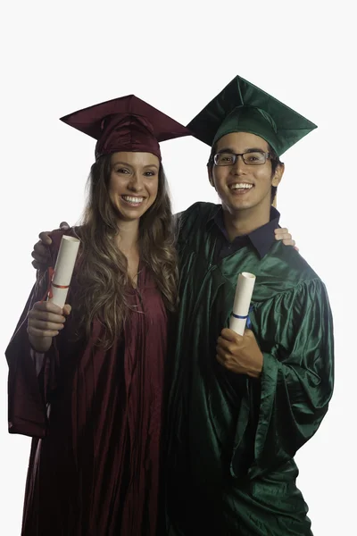 Выпускники в шапке и халате с дипломами — стоковое фото