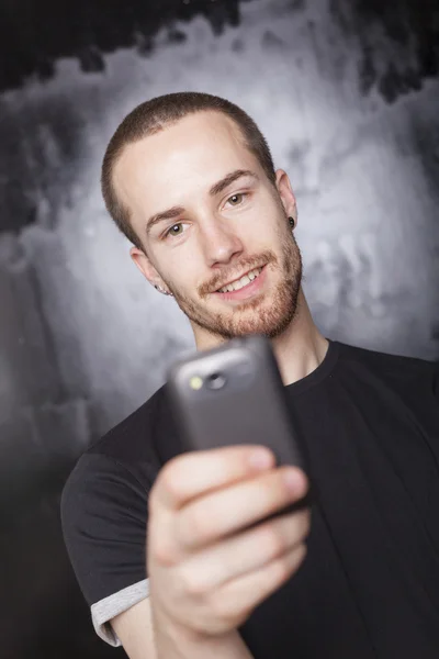 Lächelnder Mann nutzt Smartphone — Stockfoto