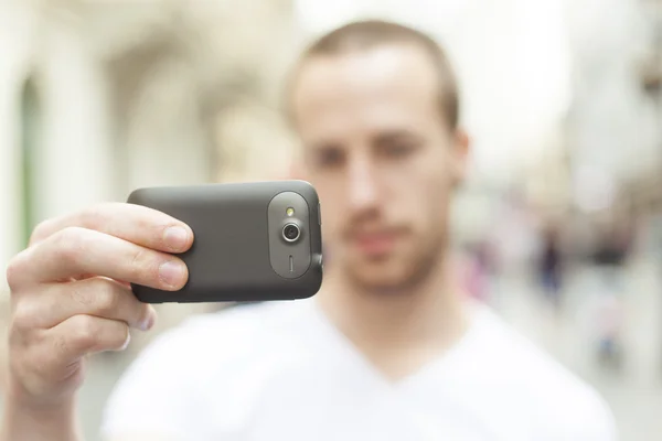 Fotógrafo urbano con teléfono mobila tomar una foto en la calle —  Fotos de Stock