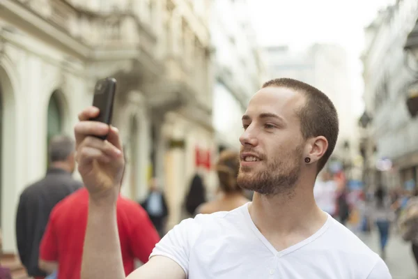 Мужчина сфотографировался с мобильным телефоном на улице — стоковое фото