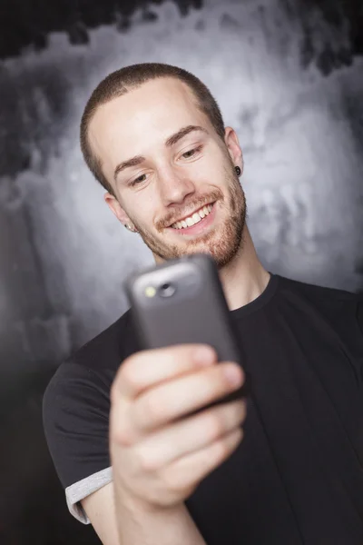 Mutlu bir adam akıllı telefon ile haber okuma — Stok fotoğraf