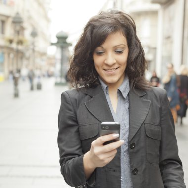 Girl with smartphone walking on city clipart