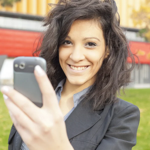 Mladá žena s pohybovými mobilní telefon — Stock fotografie
