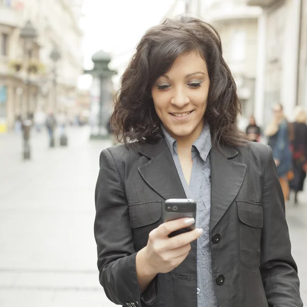 Flicka med smartphone gå på staden — Stockfoto