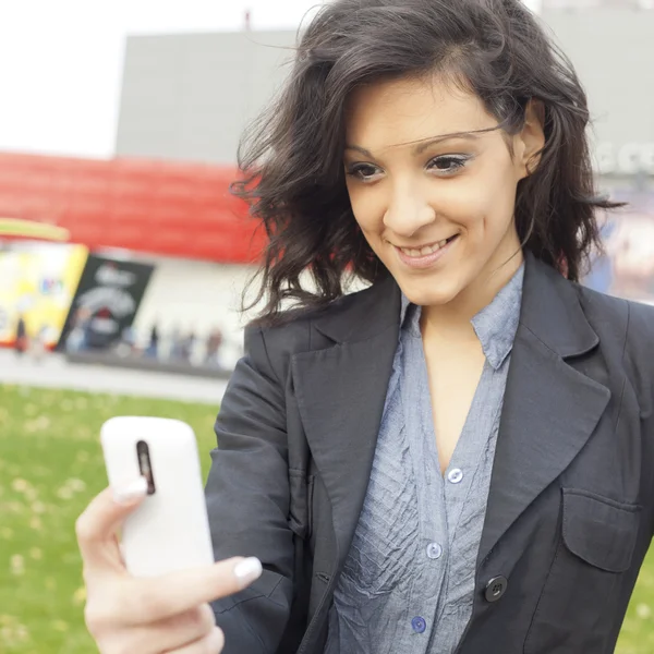 Mladá žena s pohybovými mobilní telefon — Stock fotografie