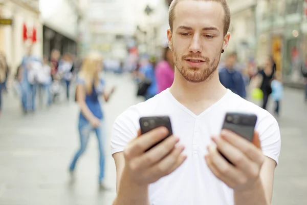 Männer müssen sich entscheiden - welches Telefon ist besser? — Stockfoto