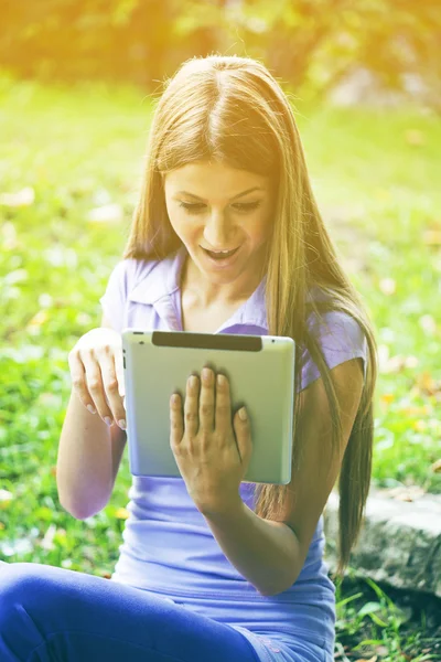 Mulher bonita com computador tablet no parque — Fotografia de Stock