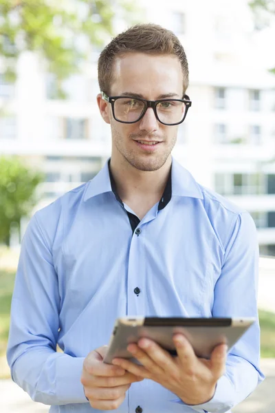 Biznesmen z komputera typu tablet w parku — Zdjęcie stockowe