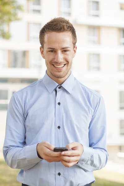 Uomo d'affari sorridente con smartphone — Foto Stock