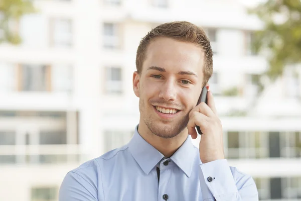 Молодий усміхнений бізнесмен на мобільному телефоні — стокове фото