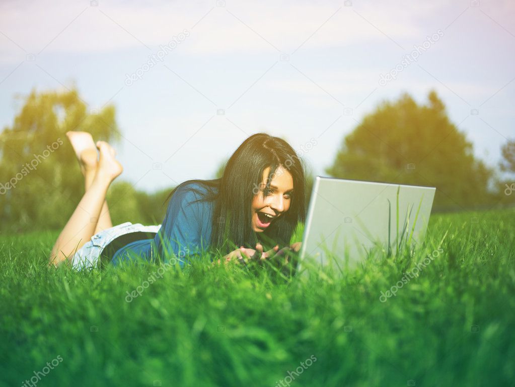 Young Girl Using Laptop In Park