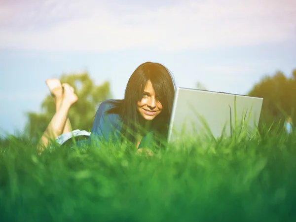 Jovem mulher usando laptop no parque — Fotografia de Stock