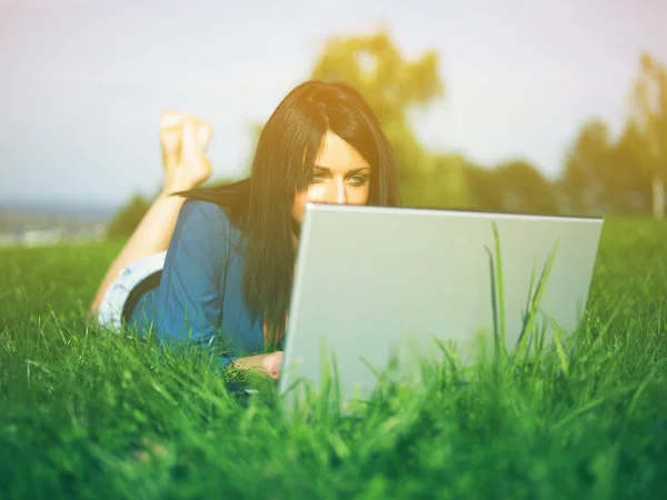 Mujer joven usando el ordenador portátil en el parque —  Fotos de Stock