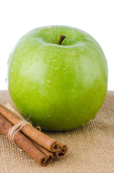 Stock image Ripe green apple with cinnamon sticks