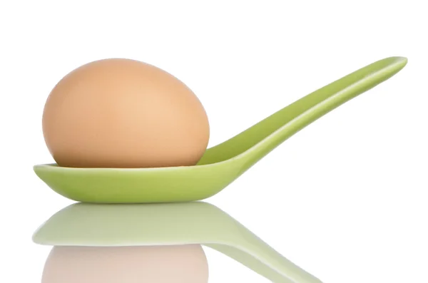 Brązowy jajko w zielony łyżka ceramiczne — Zdjęcie stockowe