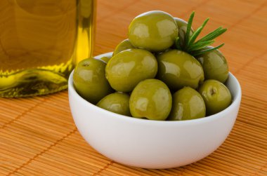 Green olives in a white ceramic bowl clipart