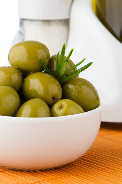 Green olives in a white ceramic bowl — Stock Photo, Image