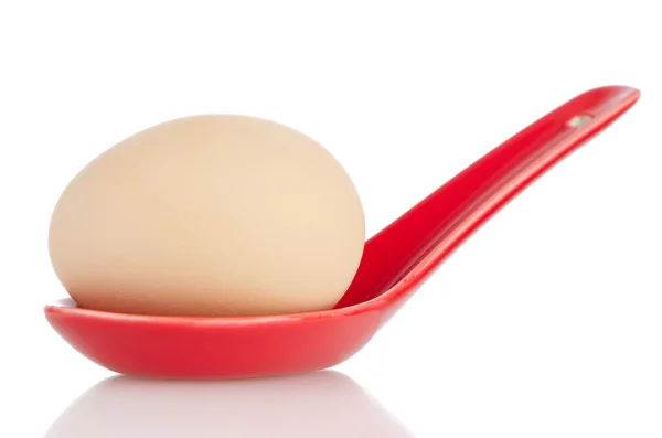 Brown egg in a red ceramic spoon — Stock Photo, Image