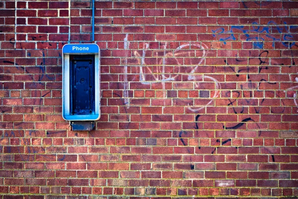 Grunge parede de tijolo com telefone público — Fotografia de Stock