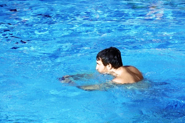 Молодой пловец в голубой воде — стоковое фото