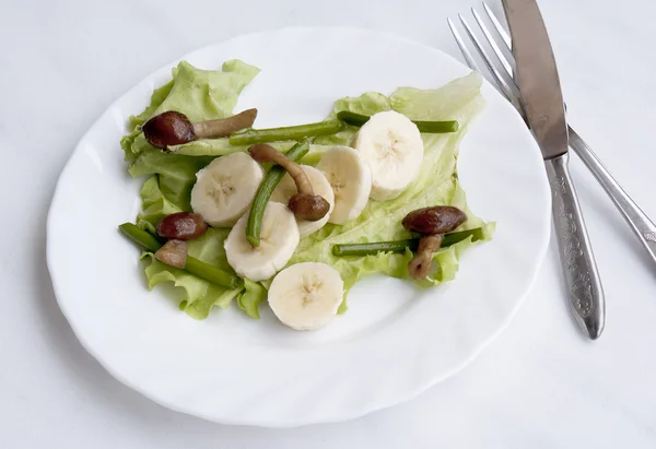 Salada criativa de fungos fritos e talos de alho e bananas doces — Fotografia de Stock