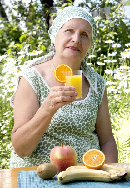 A mulher feliz com suco de laranja — Fotografia de Stock