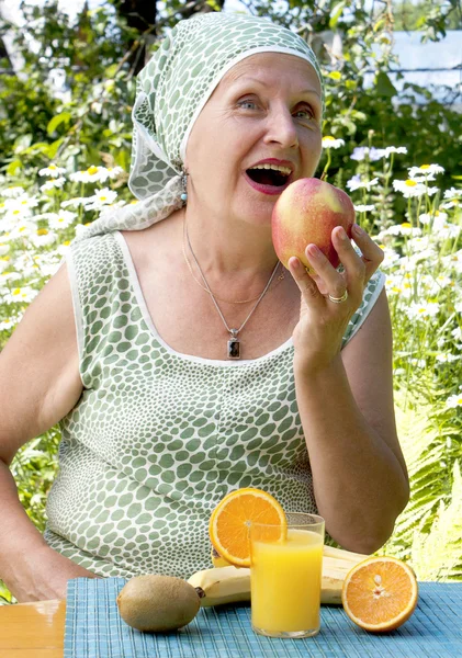 La mujer adulta come fruta fresca apetitosa — Foto de Stock