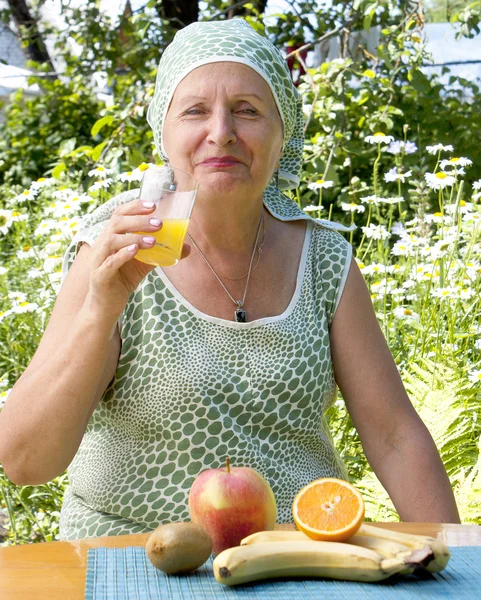 Kobieta pije sok pomarańczowy ze świeżych — Zdjęcie stockowe