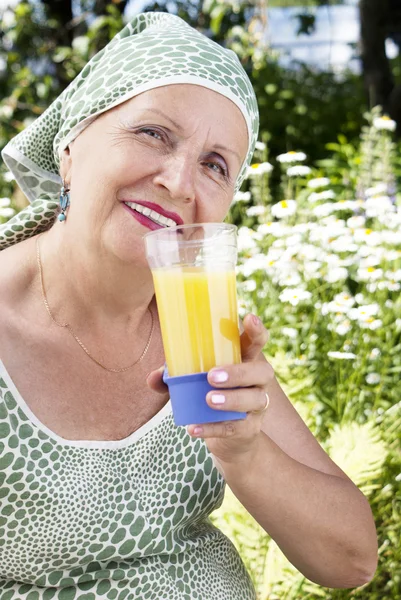 The happy female drinks fresh orange juice — Stock Photo, Image