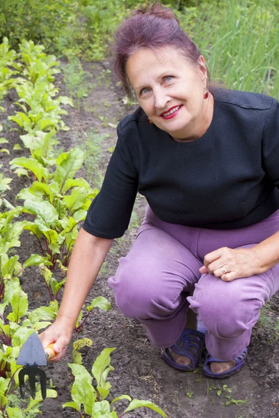 De gelukkig lachende vrouw werkt op een tuin site — Stockfoto