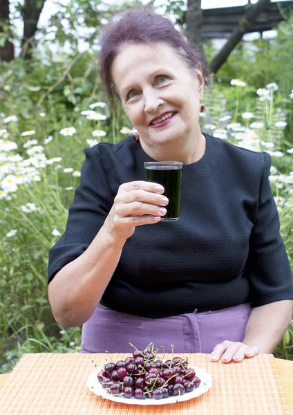 De gelukkig lachende vrouw drinkt verse kersensap — Stockfoto