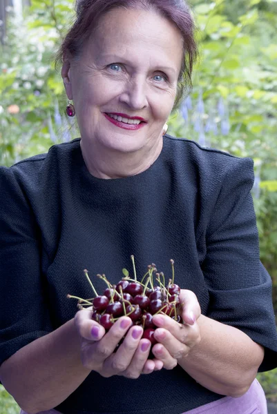 A mulher sorridente feliz com cerejas maduras — Fotografia de Stock